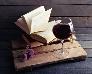 Beautiful composition with glass of wine with old books on table close up