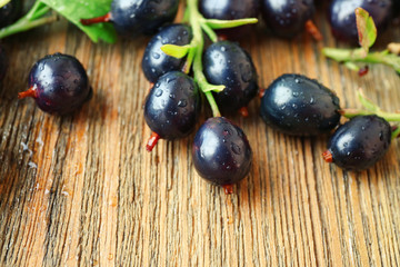 Pile of black currants on wooden table, closeup