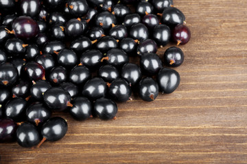 Heap of wild black currant on wooden table close up