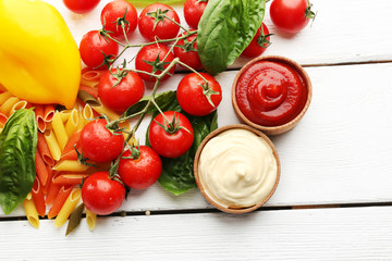 Pasta penne with tomatoes, cheese and basil on color wooden  background