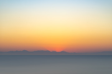 Obraz premium The sun rises over mountains in Turkey seen from Rhodes