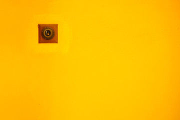 Switch light on a yellow wall.