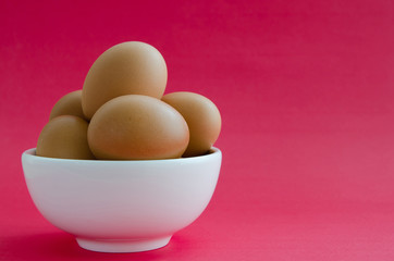 Eggs In White Bowl On Pink Background.