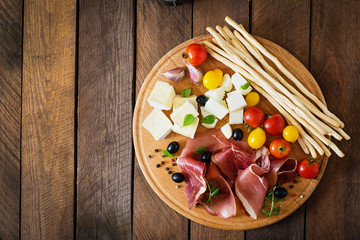 Meat appetizer on a plate on old wooden background