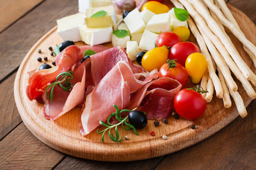 Meat appetizer on a plate on old wooden background