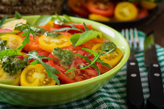 Summer tomato salad with basil, pesto and arugula