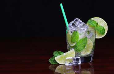 Mojito cocktail in glass with mint over black background