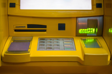 Close up of ATM keypad with withdrawal and card holes light on