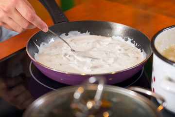 Woman cook sauce of gorgonzola in her kitchen