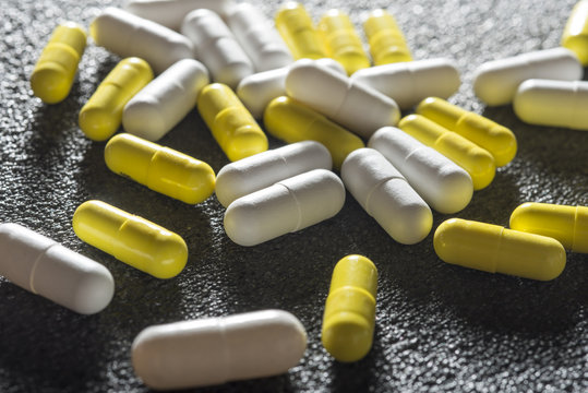 Stack of different yellow and white pills 