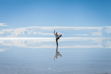 Fototapeta na wymiar Uomo pratica esercizi Yoga nel Salar de Uyuni, Bolivia
