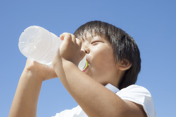 ペットボトルの水を飲む子供