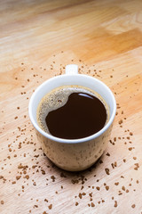 Cup of coffee and Coffee Granules on wooden table.