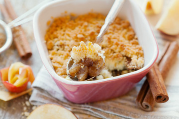 Apple crumble with cinnamon on rustic wooden table