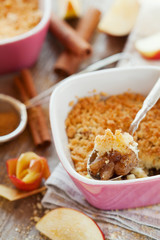Apple crumble with cinnamon on rustic wooden table