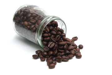 Fototapeta premium Coffee beans spilling out of a cristal jar on a white background