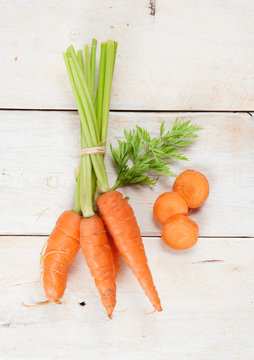Fresh washed carrots on white wooden table