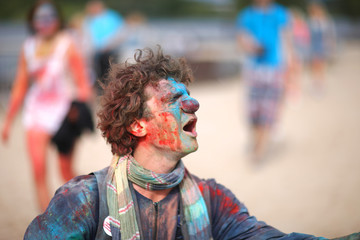 Facial expression of an impressed clown splattered with paint