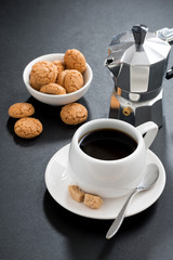 cup of coffee and italian cookies on black background