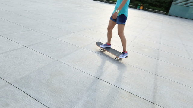 woman skateboarder riding on skateboard at city 