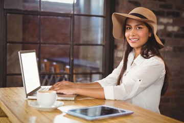 A businesswoman using her laptop while enjoying a coffee