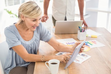 Smiling businesswoman scrolling on a tablet