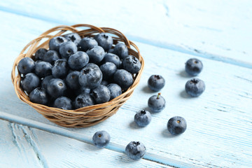 Blueberries in basket on a blue wooden background
