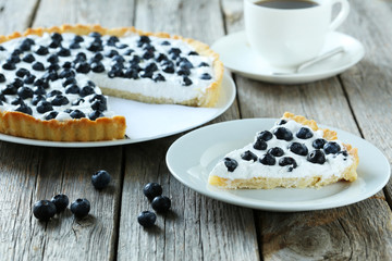 Sweet tart cake with blueberries on grey wooden background