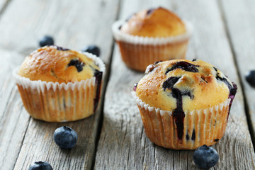 Tasty blueberry muffins on a grey wooden background