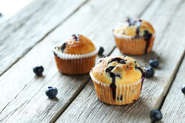 Tasty blueberry muffins on a grey wooden background