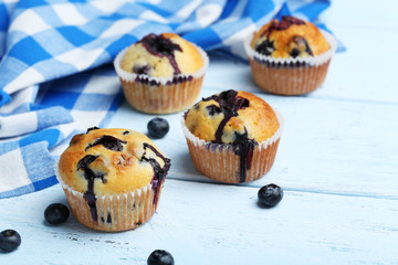Tasty blueberry muffins on a blue wooden background