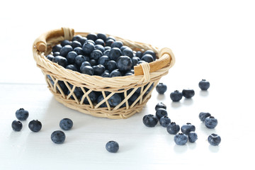 Blueberries in basket on a white wooden background