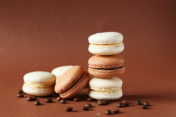 Coffee macarons with coffee beans on brown background