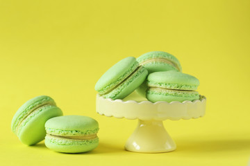 Green macarons on yellow paper background