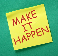 The phrase Make It Happen in red text on a yellow sticky note attached to a green notice board as a source of motivation