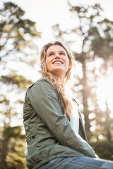 Young happy jogger sitting on rock and looking away