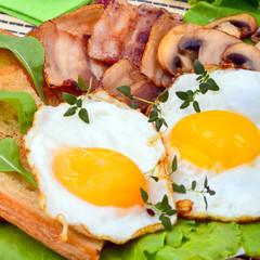 Scrambled eggs and bacon on plate on wooden table