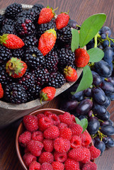 Blackberries, strawberry, raspberry and grapes in a wooden baske