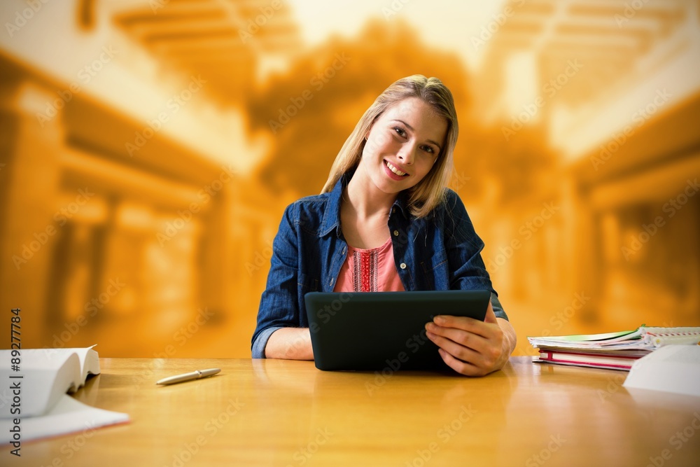 Canvas Prints Composite image of student studying in the library with tablet