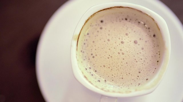 human hand taking mix coffee in white cup with spoon