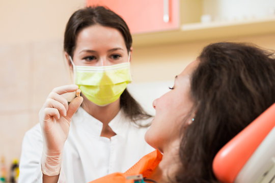 Dentist with patient's tooth
