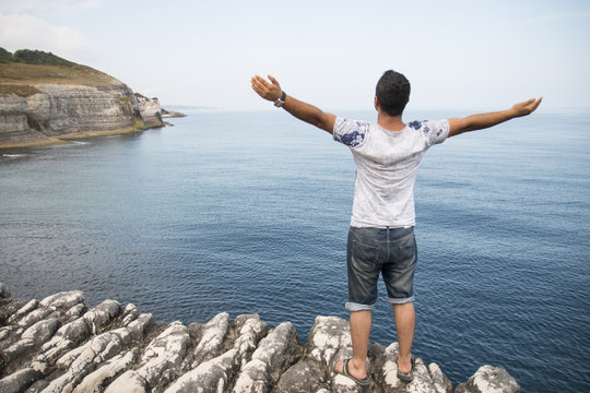 manzaraya karşı kollarını a&ccedil;an adam