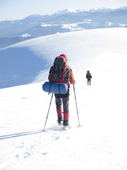 A man in snowshoes is the snow.