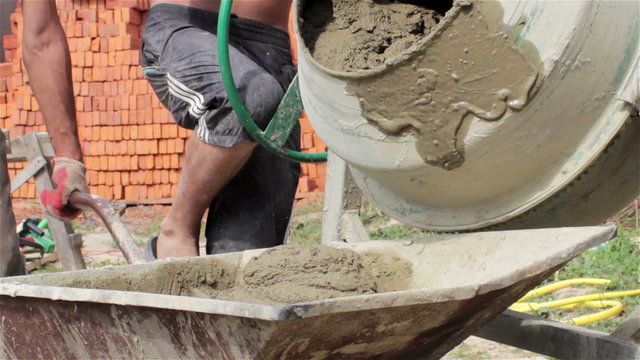 concrete mixer with cement/prepared solution of concrete pouring cement mixer at a construction site in a wheelbarrow