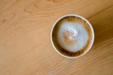 Top view of hot capuccino coffee in paper cup