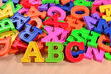 Fototapeta premium Plastic colored letters ABC on a wooden background