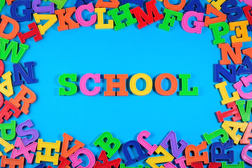 School written by plastic colorful letters on a blue