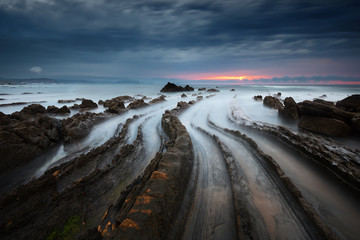 flysch rocks in barrika beach at sunset