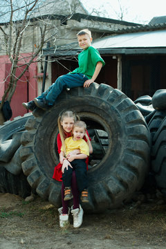 children playing in junkyard tires