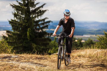 Fototapeta premium Biking in the Franconian Hills in Northern Bavaria. Young man on